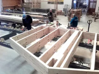 Vereinsmitglieder streichen die Außenschalung, Sparren und Pfetten in der Zimmerei